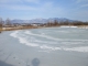 雪が波打つため池